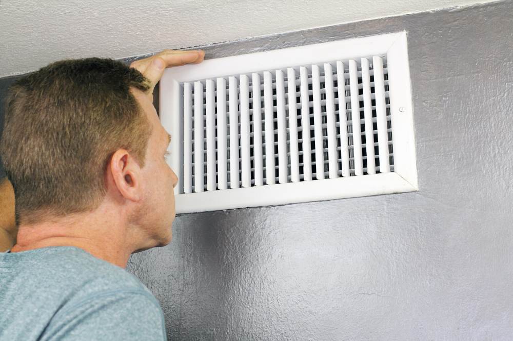 Man Looking At His Home Air Duct
